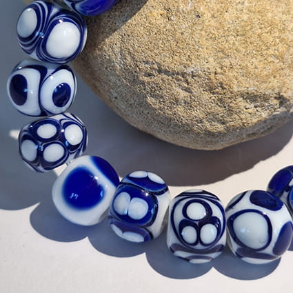 Ręcznie wykonana bransoletka ze szkła artystycznego  lampwork w odcieniach błękitu, granatu i bieli zbliżenie koralików
