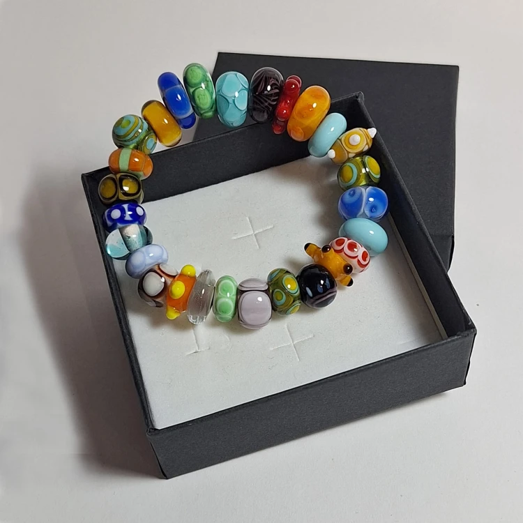 Bransoletka Tęczowy Świat ze szkła artystycznego  lampwork oparta o pudełko