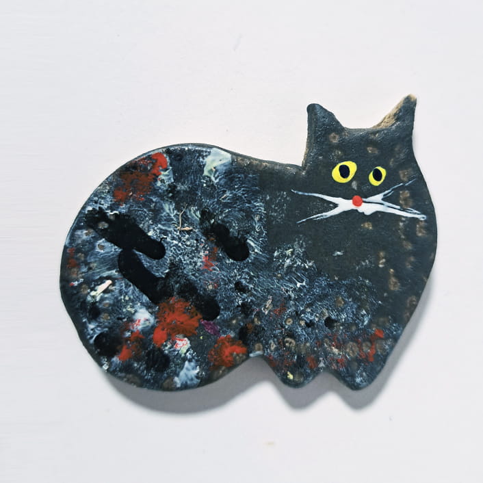 Wykonany ręcznie, ceramiczny magnes na lodówkę czarny kot mruczek w fantazyjnej chmurze kolorów